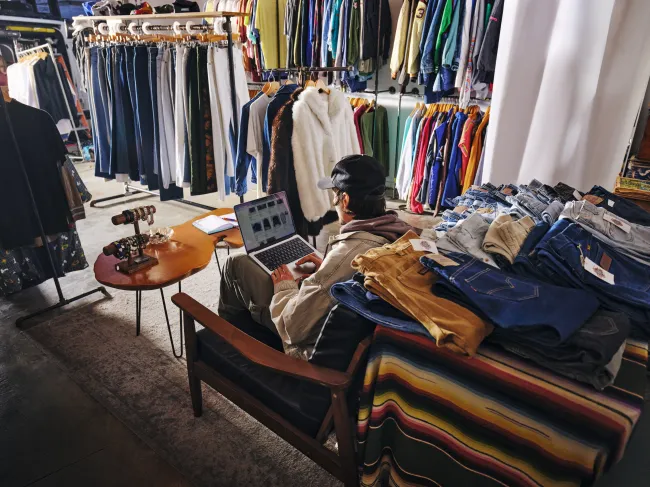 Man on a computer in a clothing shop