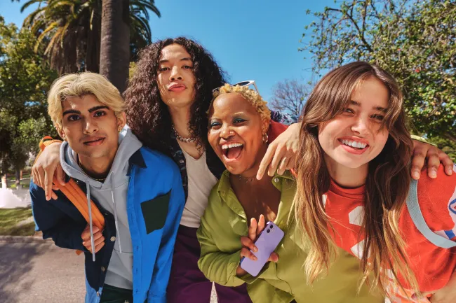 A group of young adults looking at the camera and smiling